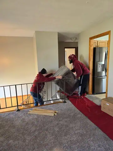 Naglee movers carrying items through a home interior [verify]