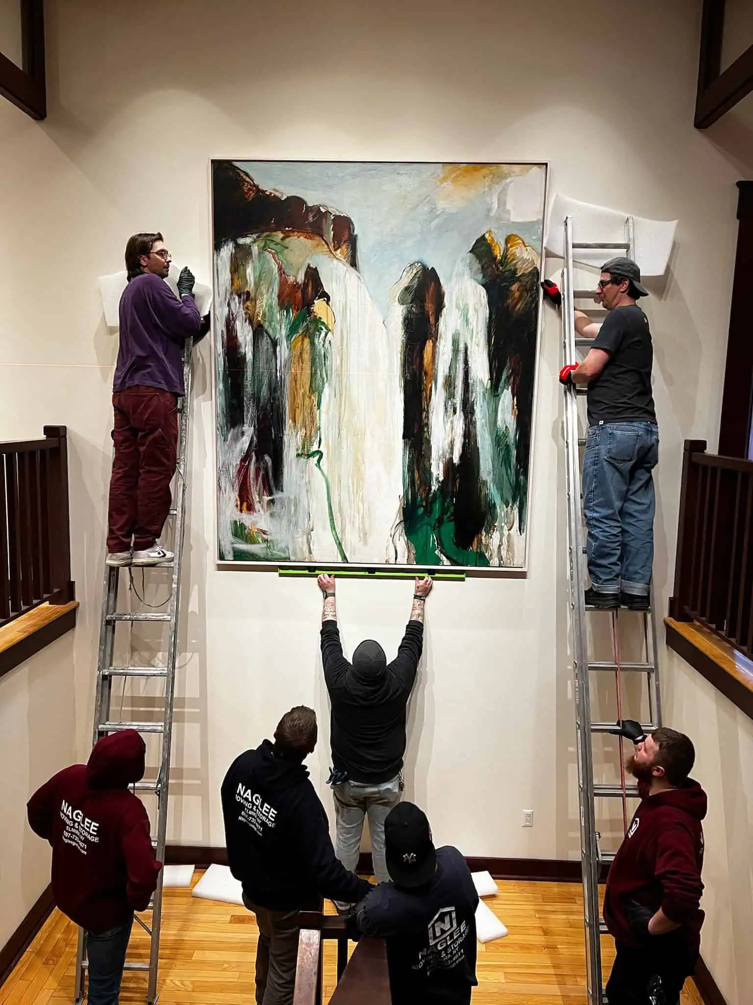Framed artwork being handled by Naglee Fine Arts staff