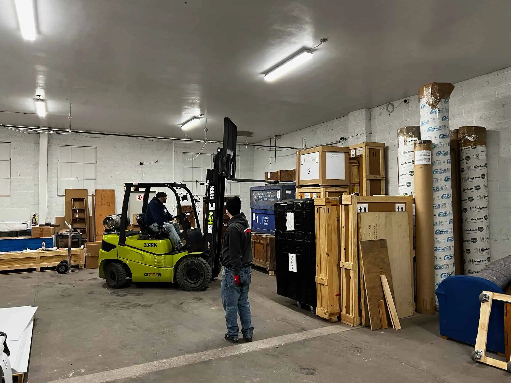 Forklift moving crated goods inside Naglee's warehouse